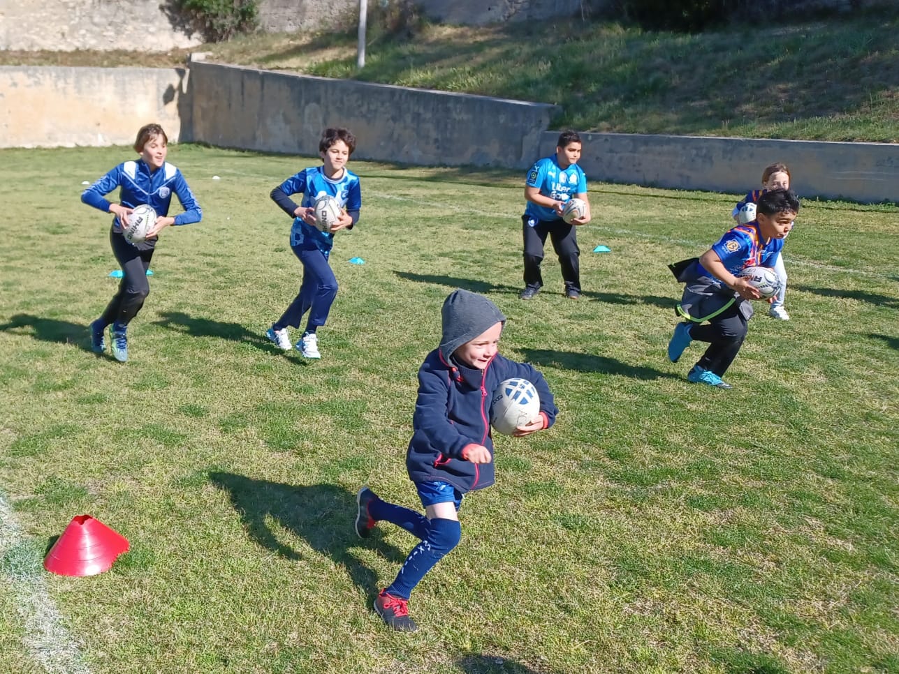images des enfant de l'école de rugby Marseille XIII Avenir courant avec un ballon lors d'un entrainement